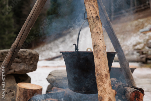 Obraz na płótnie grande pentola di metallo in cui viene cucinata della polenta alla brace, all'aperto, in inverno w salonie
