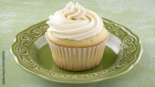A Delectable Vanilla Cupcake with Creamy Frosting on a Green Plate