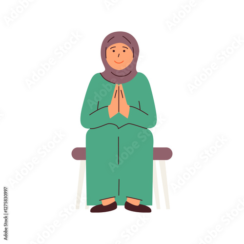 A woman in a hijab sits serenely her hands clasped in prayer