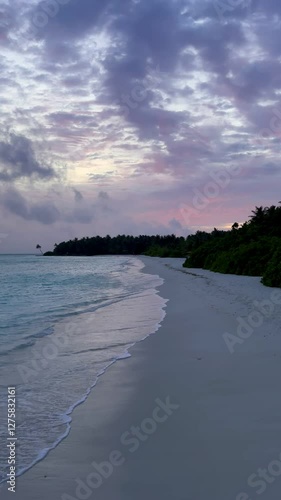 Sunset on beach in Maldives with ocean waves