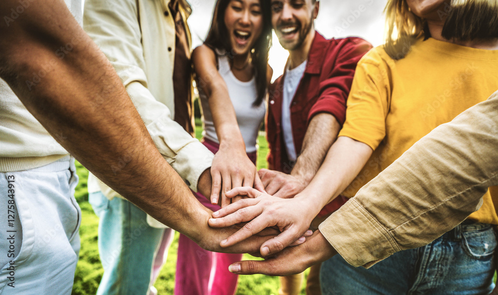 Obraz premium Multiracial group of young people stacking hands outdoors - Happy friends celebrating success on city street - Youth community concept with guys and girls standing together supporting peace and love