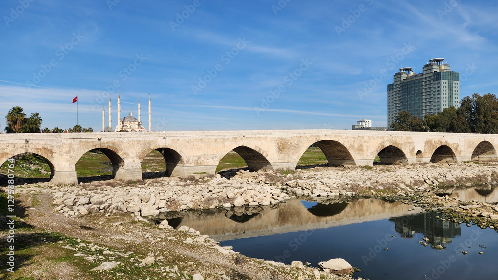 Fototapeta premium The historic arched stone bridge called Taşköprü, one of the symbols of Adana, located on the Seyhan River, was built by the Roman architect Auxentus in 384 AD.