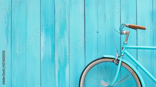 Turquoise Bicycle Against Blue Wood - A teal bicycle leans against a light blue wooden wall. Perfect for travel, summer, or transportation themes photo