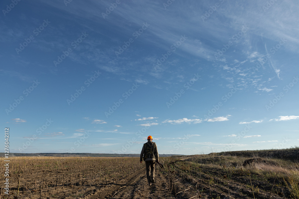 Mature man hunter with gun while walking on field. Mature man hunter with gun while walking on field.