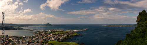 Expansive Coastal Cityscape with Vibrant Harbor, Rolling Hills, and Deep Blue Ocean Viewed from Hallasan Mountain photo