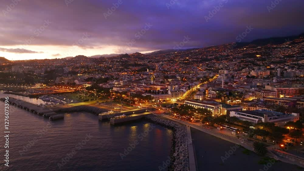 View of illuminated harbor and city skyline at sunset by the coast in Madeira View of illuminated harbor and city skyline at sunset by the coast in Madeira