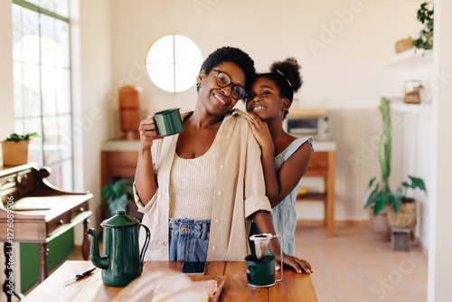 A mother and daughter morning: Woman enjoying drip coffee and her daughter's company at home photo