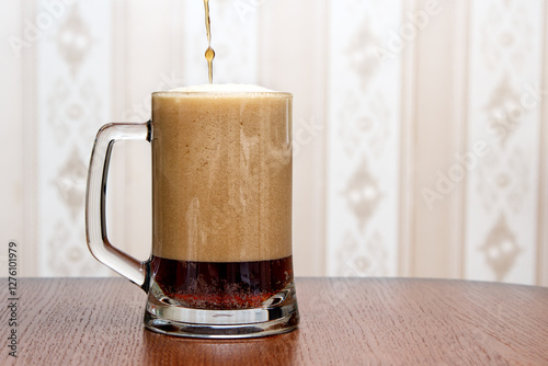 Obraz na płótnie dark beer is poured into a glass mug w salonie