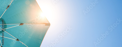 Obraz na płótnie beach sun umbrella on blue summer sky w salonie