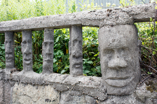 Obraz na płótnie stone fence with human faces w salonie