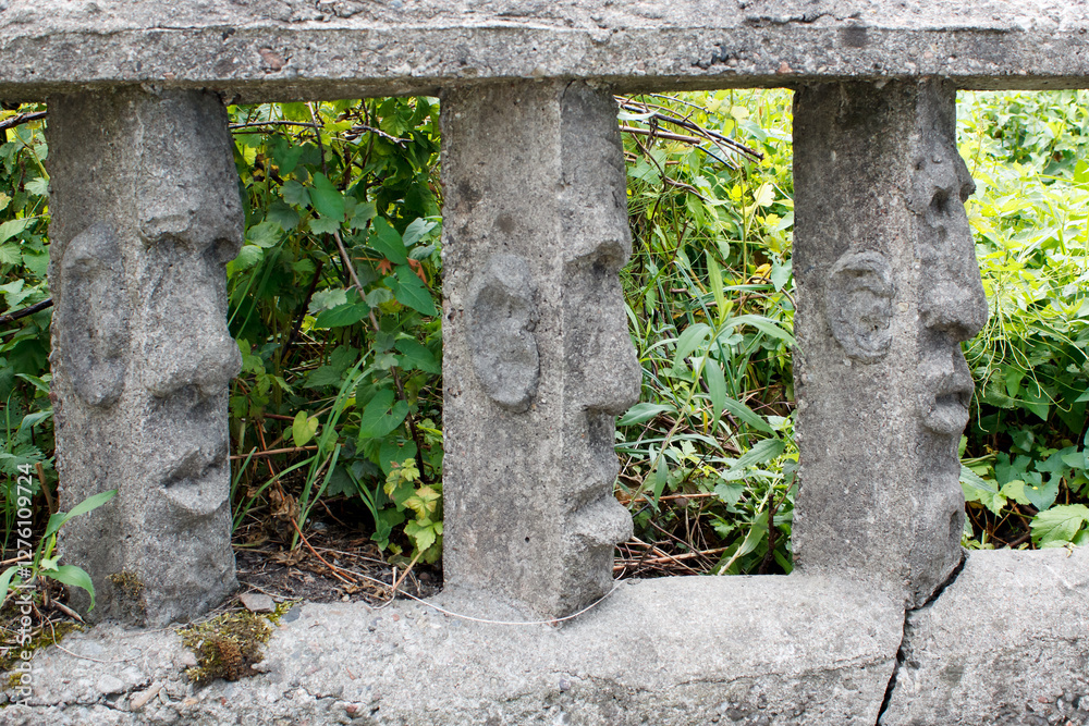 stone fence with human faces
