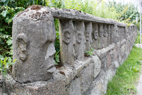 Obraz na płótnie stone fence with human faces w salonie