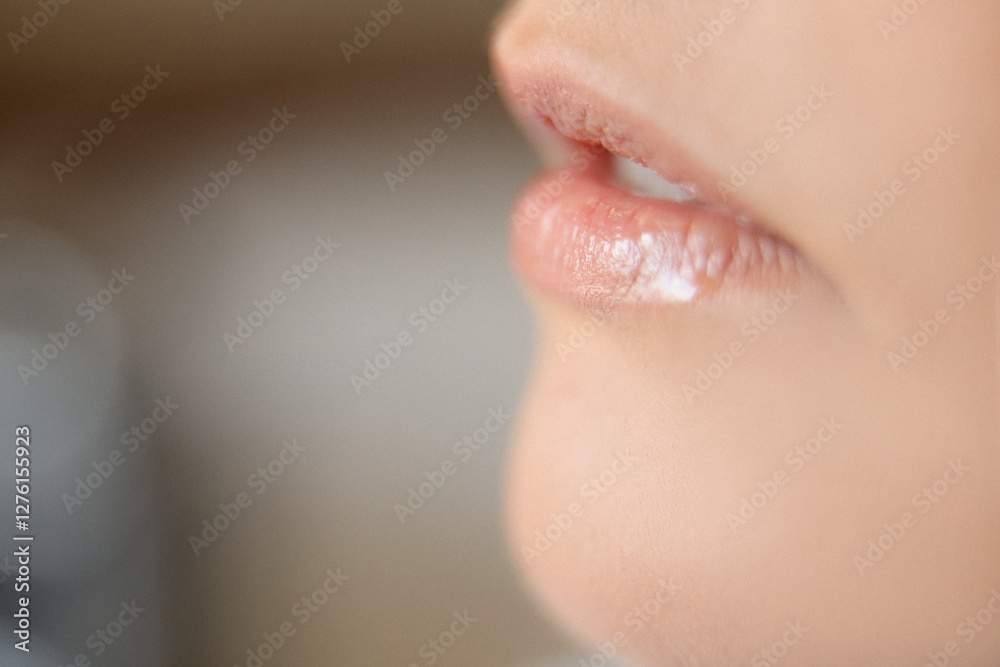 Obraz premium close up of a young woman applying lip gloss