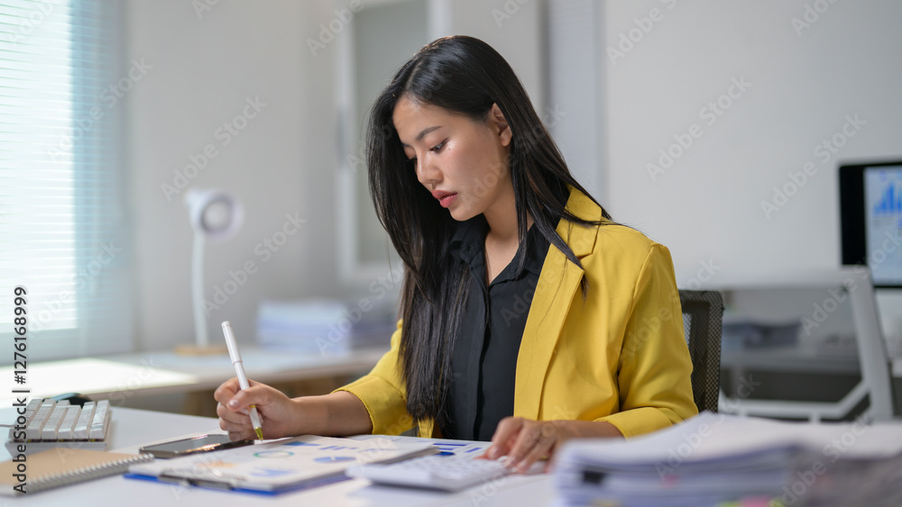 A woman is sitting at a desk and writing with a pen A woman is sitting at a desk and writing with a pen