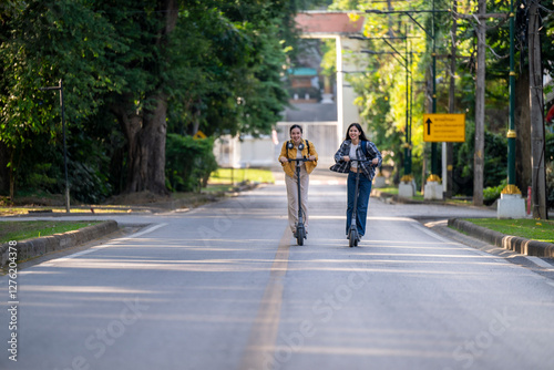 Wallpaper Mural Two people riding scooters down a street Torontodigital.ca