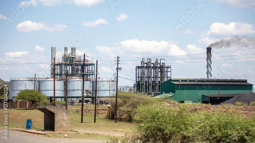 Industrial facility in South Africa. Sugarcane processing plant or ethanol refinery in a rural area, blue cloudy sky