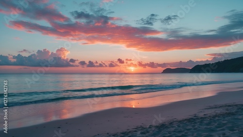 Coastal sunset with vibrant colors reflected in calm water and gentle waves on a sandy beach with distant hills under cloudy sky photo