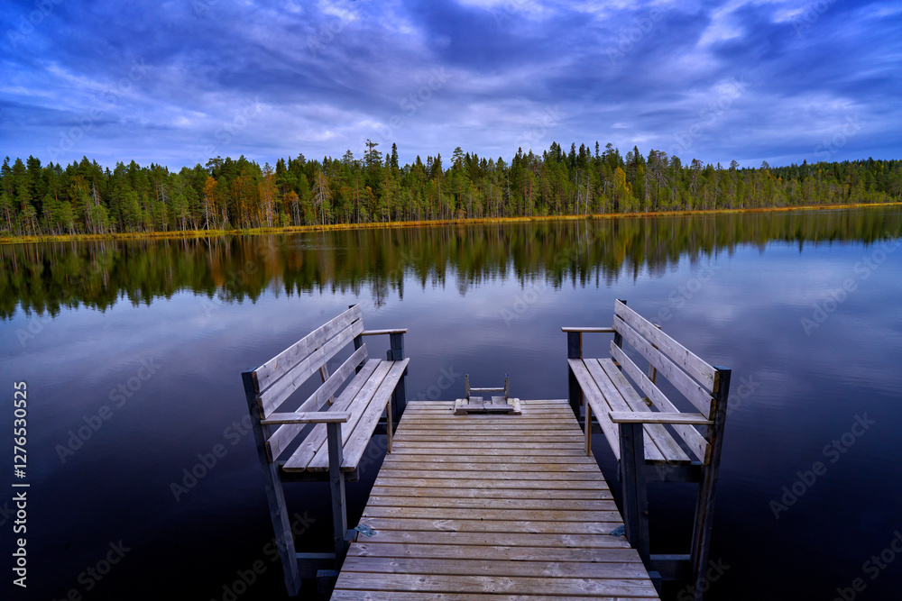 Naklejka premium Autumn landscape from Finland. Pine forest coast with lake and dark blue sky with white clouds. Beautiful scenery from north of Europe.