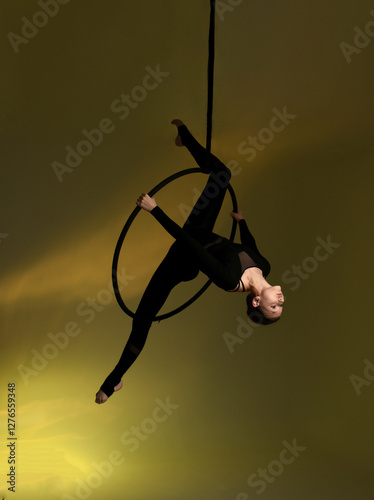 Aerial gymnastics. Gymnast on aerial hoop. Athlete trains on aerial hoop