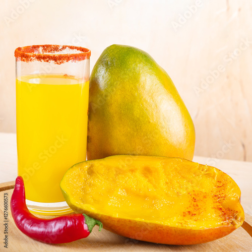 Close-up of mangonada mexican smoothie drink made from mango and chili powder in glass on wooden table photo