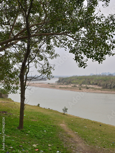 A serene riverscape with a gently flowing river bordered by grassy banks.