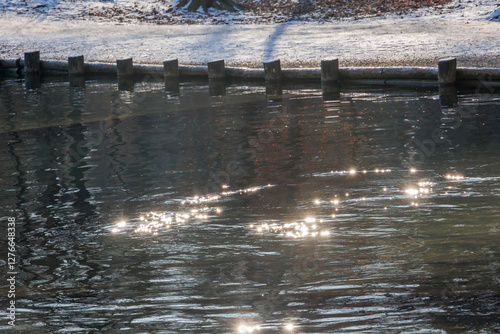 Sunlight sparkling on rippling water at Stempflesee, Augsburg, Germany – February 19, 2025.. photo