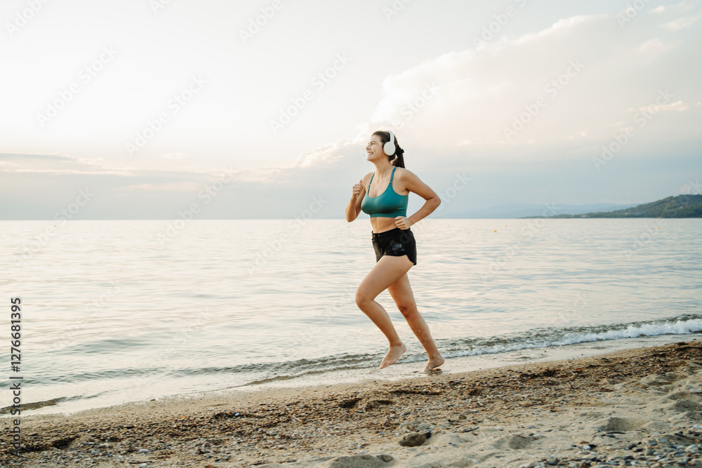 Young woman running or jogging on the beach at sunset Young woman running or jogging on the beach at sunset