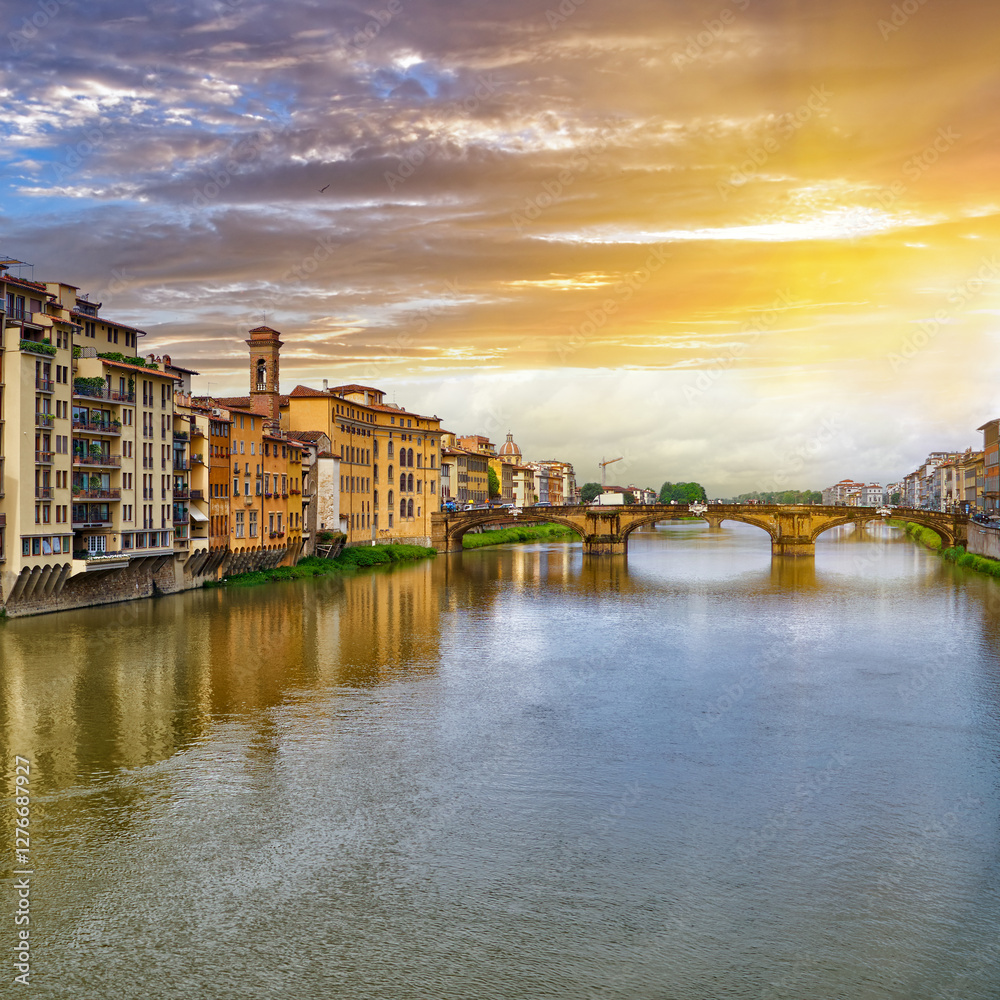 Fototapeta premium Scenic sunset cityscape over Arno River, St Trinity Bridge and colorful old houses along the river in Florence city