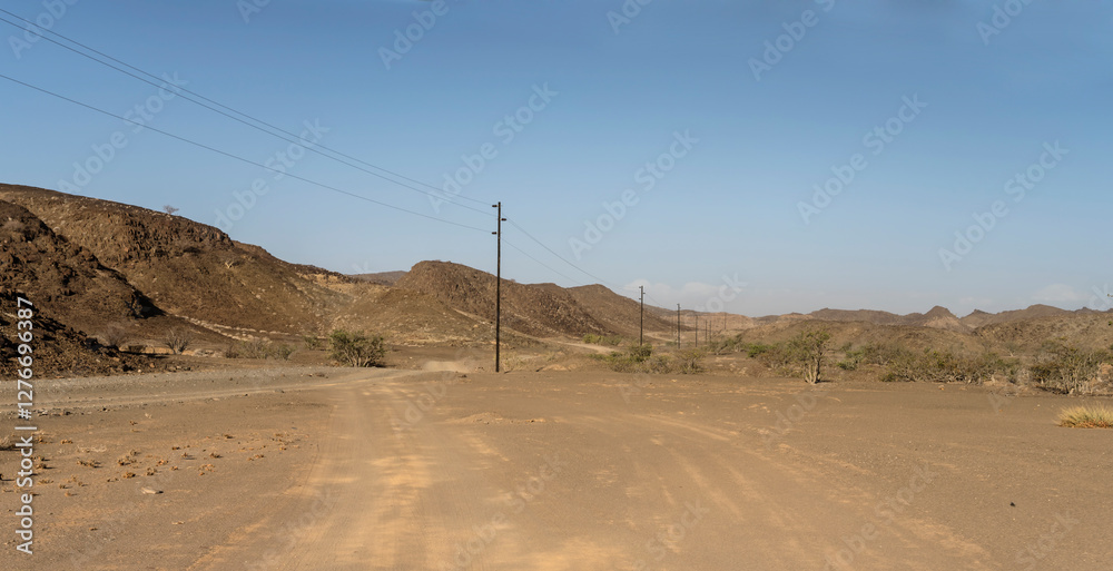electric line and winding dirt road in desert, near De Riet, Namibia
