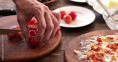 Butter board preparing, cutting cherry tomato using small kitchen knife making topping, close up