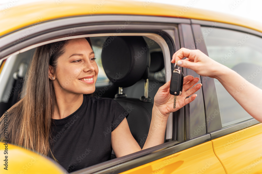 A smiling woman sitting in a yellow car receives a set of keys from another person, symbolizing a car purchase, rental, or ownership transfer.