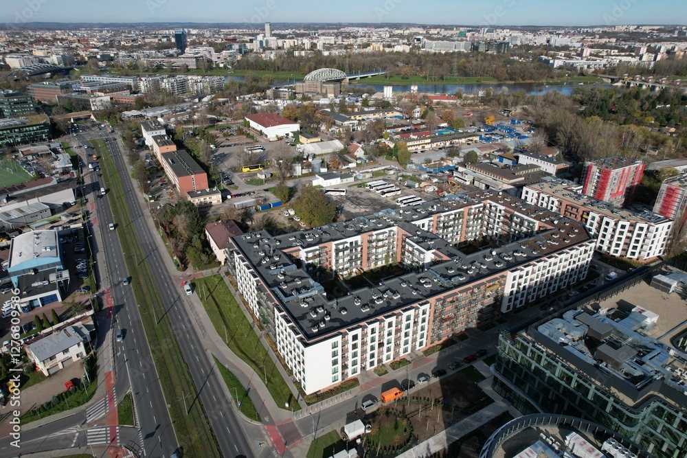 Fototapeta premium An aerial view of Kraków’s Zabłocie district, showcasing its dynamic transformation along the banks of the Vistula River. Once an industrial area, Zabłocie has evolved into a modern, thriving neighbor