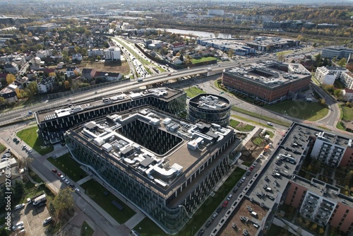An aerial view of Kraków’s Zabłocie district, showcasing its dynamic transformation along the banks of the Vistula River. Once an industrial area, Zabłocie has evolved into a modern, thriving neighbor