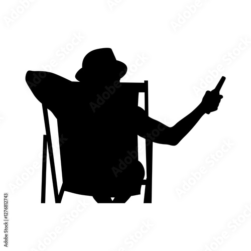 A silhouette of a person sitting on a deck chair, legs stretched out, toes touching the sand.  