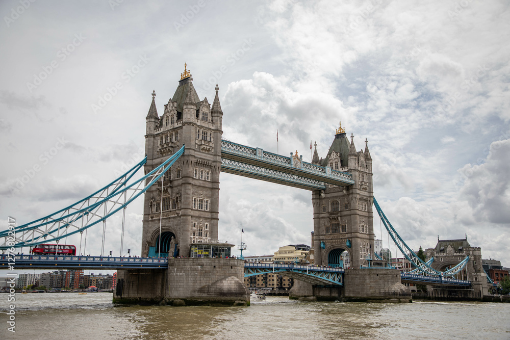 Obraz premium London, England: tower bridge with a red city bus on a clouded day