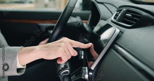 Female hand touches navigation on car monitor screen Close up of woman hand driver entering an address into the navigation system in modern car.