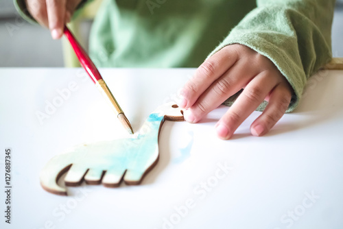 Fototapeta Naklejka Na Ścianę i Meble -  Toddler painting a dinosaur with watercolors