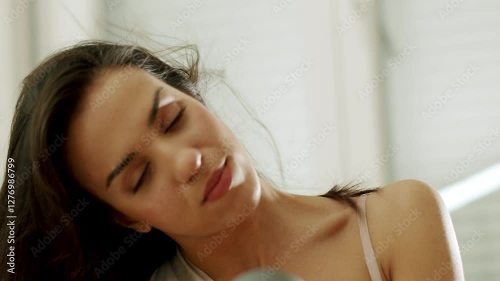 Brunette woman in a bathrobe dries her beautiful hair with a hairdryer in slow motion Brunette woman in a bathrobe dries her beautiful hair with a hairdryer in slow motion