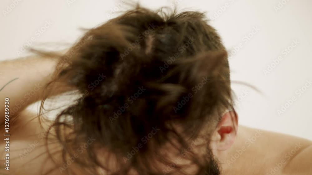 Young man having his hair  and beard blow-dried in slow motion.