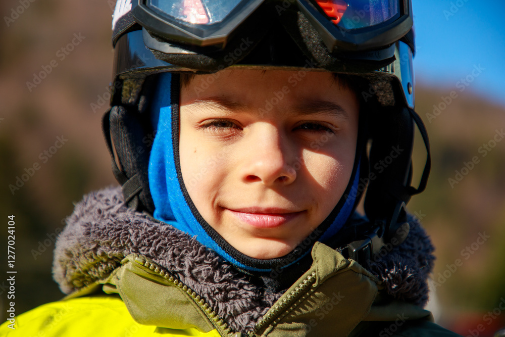 Portrait of little boy in ski equipment at ski resort
