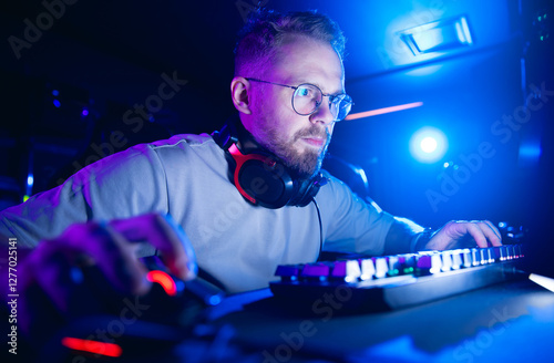 Focused caucasian young adult male gamer engaged in intense online gaming session, cybersport banner