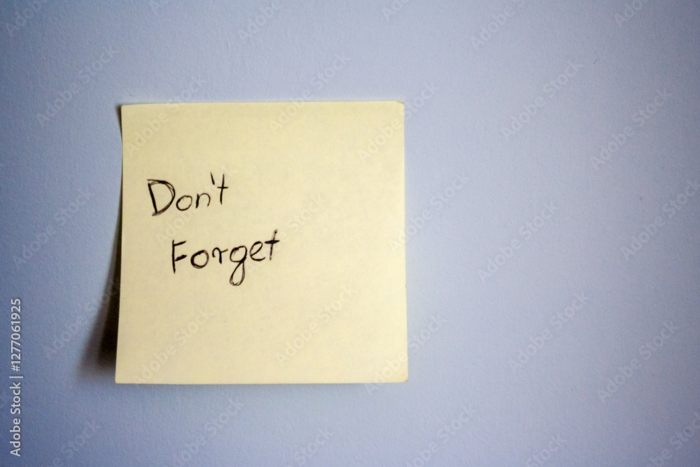A simple sticky note on a blue wall, featuring the handwritten message A simple sticky note on a blue wall, featuring the handwritten message