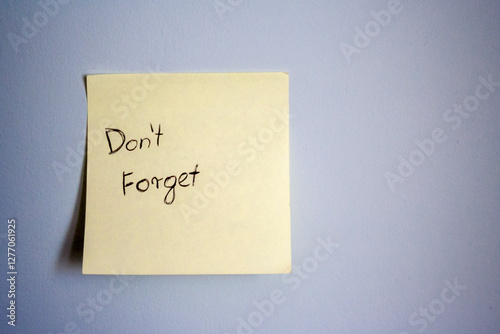 A simple sticky note on a blue wall, featuring the handwritten message 