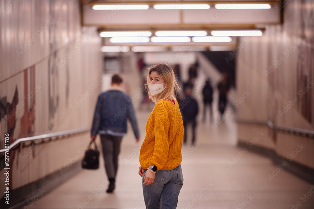 Obraz premium Woman in Yellow Sweater Wearing a Mask in a Subway Tunnel