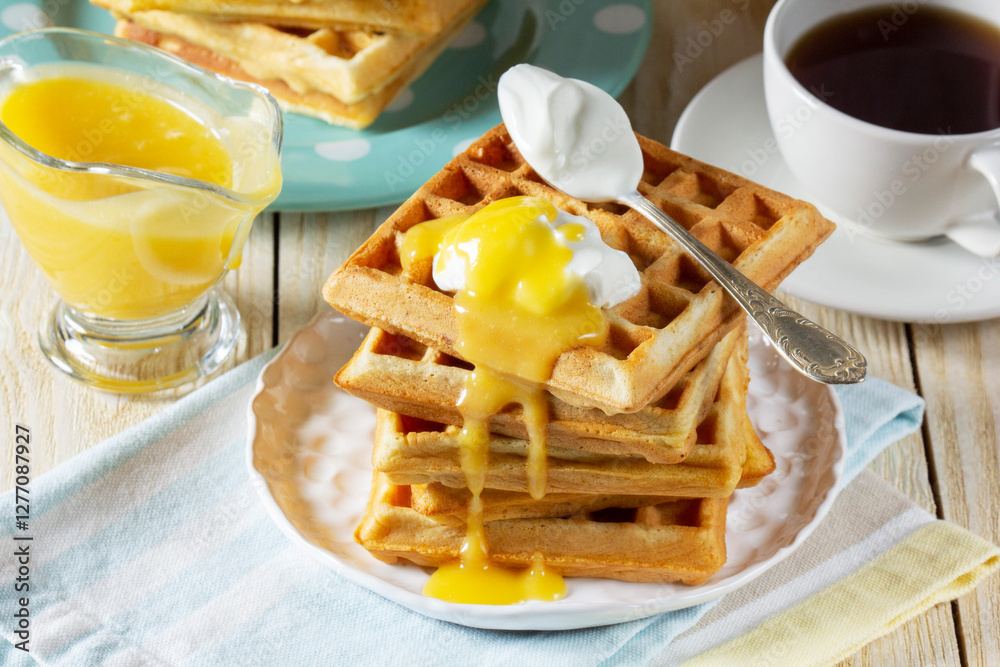 Belgian waffles with cream and lemon curd, served with tea.