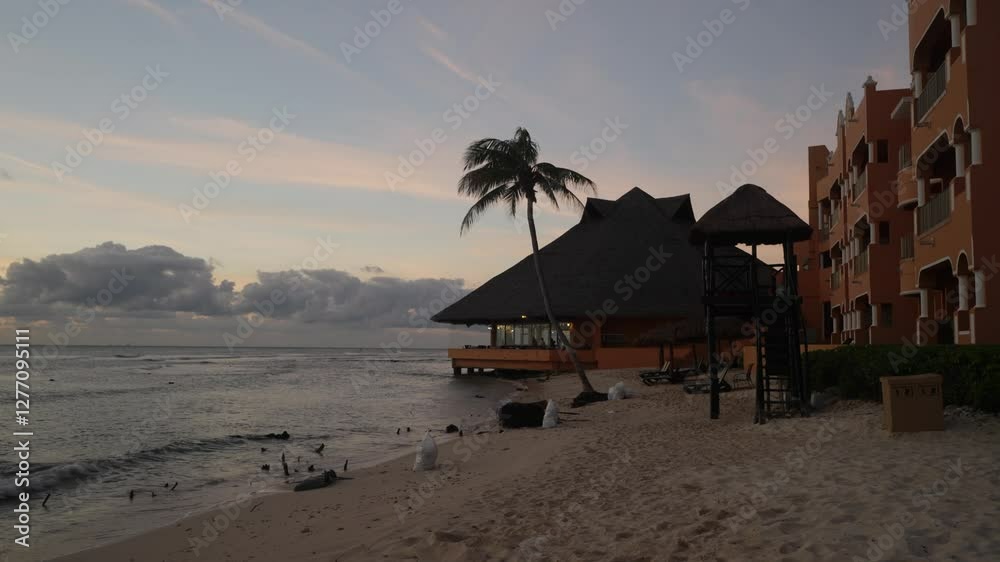 Scenic view of small waves rolling onto a tropical beachfront resort in Mexico during sunset Scenic view of small waves rolling onto a tropical beachfront resort in Mexico during sunset