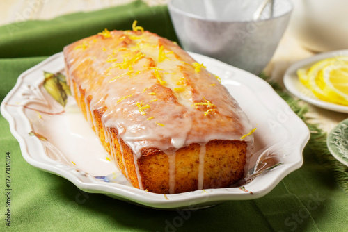 Obraz na płótnie Aromatic lemon cake, covered with sugar icing and sprinkled with zest, served with tea. w salonie