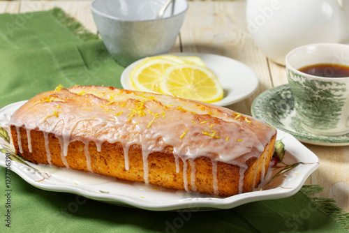 Obraz na płótnie Aromatic lemon cake, covered with sugar icing and sprinkled with zest, served with tea. w salonie