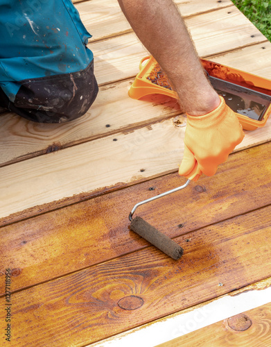 Wallpaper Mural Man is painting a wooden floor with a roller Torontodigital.ca