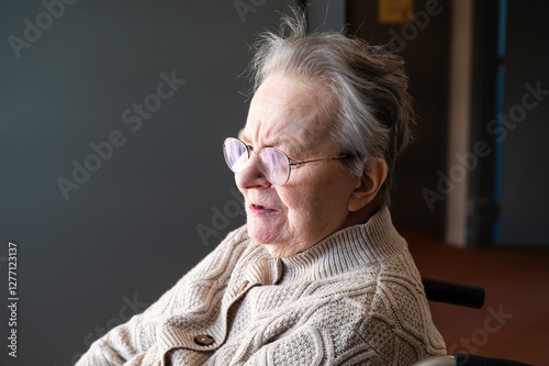 Expressive portrait of an 86 yo grandmother sitting in a wheelchair home in Tienen, Flemish Brabant, Belgium photo